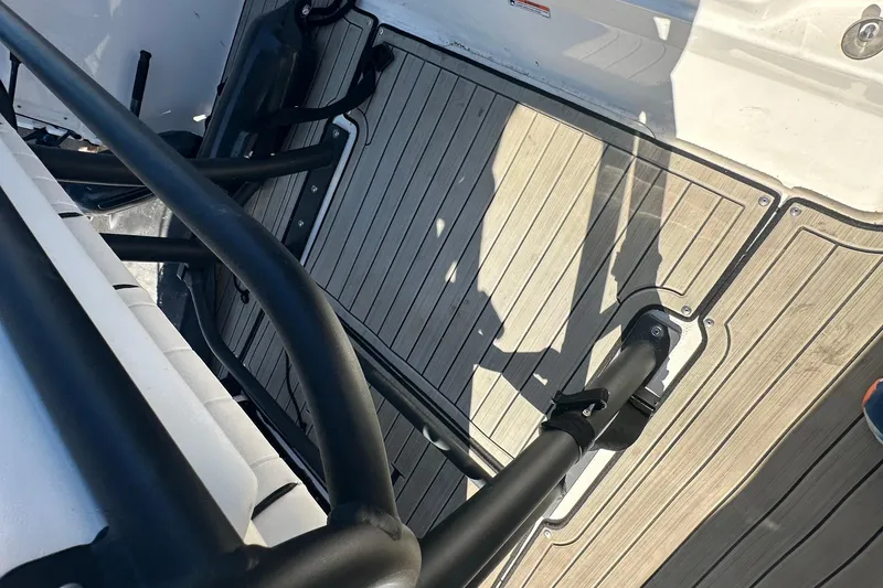 Slide: The Image of 2023 Yamaha Boats 252 FSH Sport deck with sleek black railings and wood-patterned flooring. - 20