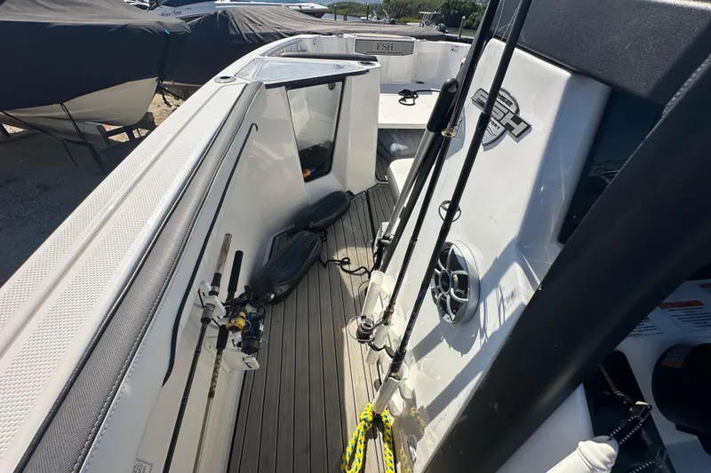 Slide: The Image of 2023 Yamaha Boats 252 FSH Sport interior with fishing rods and sleek design. - 26