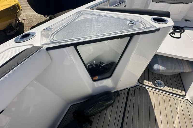 Slide: The Image of 2023 Yamaha Boats 252 FSH Sport interior detail with storage compartment and cup holders. - 27