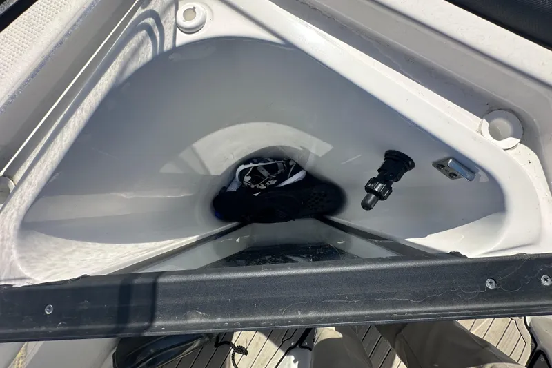 Slide: The Image of Storage compartment in 2023 Yamaha Boats 252 FSH Sport, featuring interior view with items. - 30