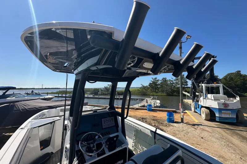 Slide: The Image of 2023 Yamaha Boats 252 FSH Sport at dock, featuring rod holders and control console. - 49