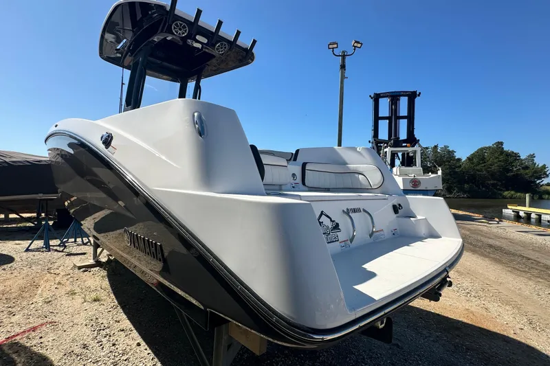 Slide: The Image of 2023 Yamaha Boats 252 FSH Sport, sleek design, docked outdoors under clear blue sky. - 6