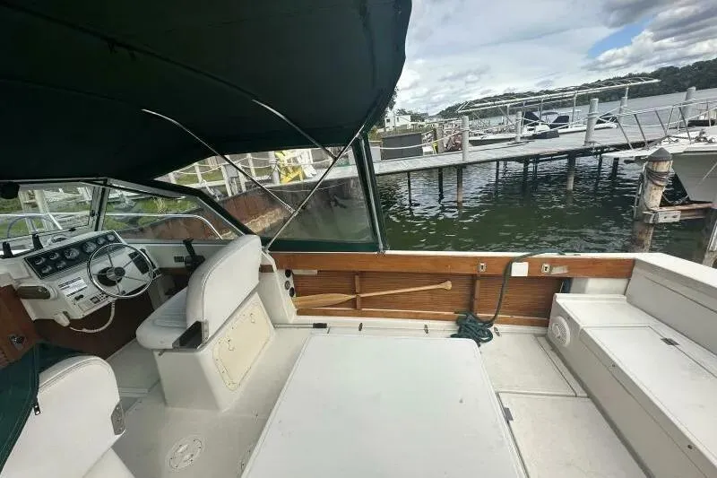 Slide: The Image of 1997 Limestone 24 Cuddy boat interior with helm, seating, and dock view. - 11