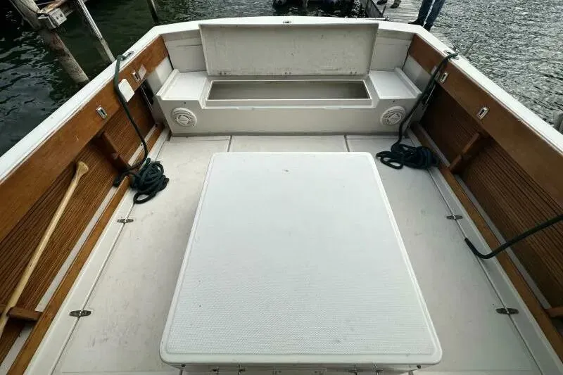 Slide: The Image of 1997 Limestone 24 Cuddy boat interior with open storage compartment and wooden accents. - 12