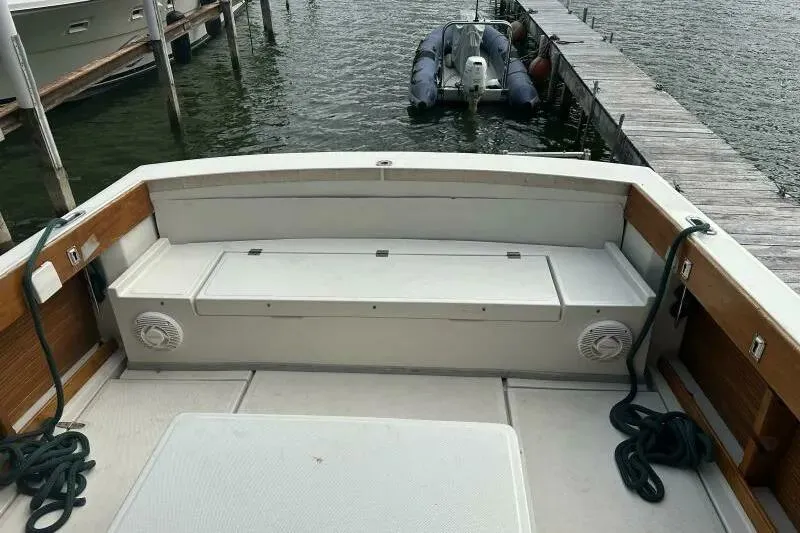 Slide: The Image of 1997 Limestone 24 Cuddy boat interior with seating, docked by the water. - 13