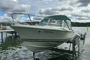 Slide: The Image of 1997 Limestone 24 Cuddy boat docked on a lake under cloudy skies. - 4