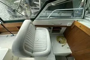 Slide: The Image of 1997 Limestone 24 Cuddy boat interior with cushioned seating and wooden accents. - 9