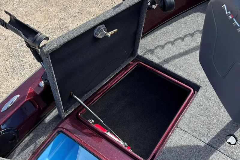 Slide: The Image of 2021 Tracker Nitro ZV21 boat storage compartment with open lid and key. - 13
