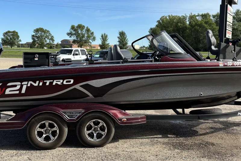 Slide: The Image of 2021 Tracker Nitro ZV21 boat on trailer, parked outdoors on a sunny day. - 2