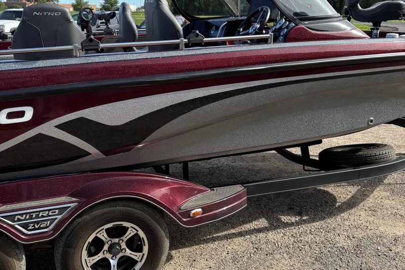 Slide: The Image of 2021 Tracker Nitro ZV21 boat with sleek design and metallic finish on a trailer. - 23