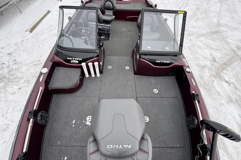 Slide: The Image of 2021 Nitro ZV21 boat interior with dual consoles and seating on snowy ground. - 32