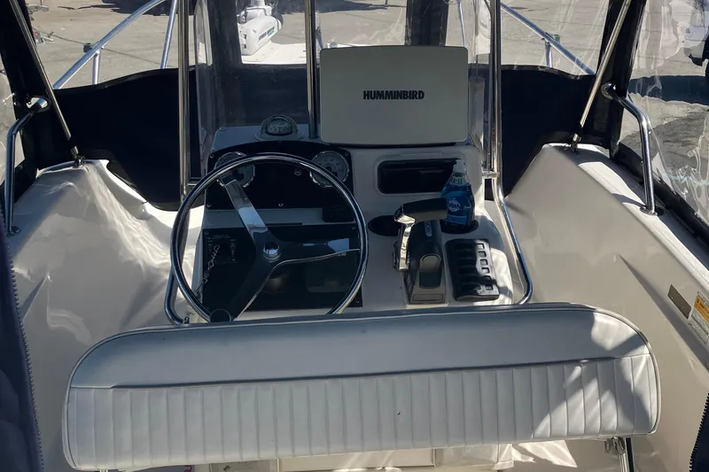 Slide: The Image of 2002 Boston Whaler 160 Dauntless boat cockpit with steering wheel and controls. - 6