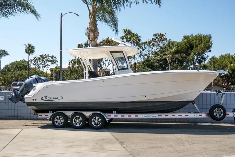 Slide: The Image of 2023 Robalo R302 Center Console boat on trailer, parked outdoors. - 1