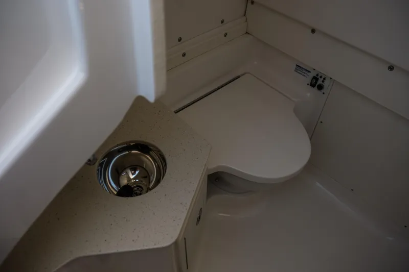 Slide: The Image of 2023 Robalo R302 Center Console boat bathroom interior with sink and toilet. - 16