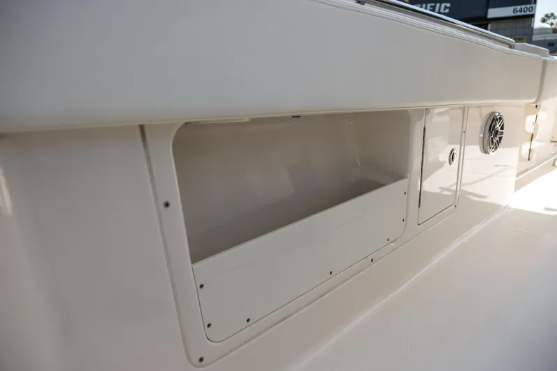 Slide: The Image of 2023 Robalo R302 Center Console boat storage compartment and speaker detail. - 18