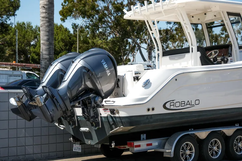 Slide: The Image of 2023 Robalo R302 Center Console boat with dual Yamaha outboard engines on a trailer. - 2