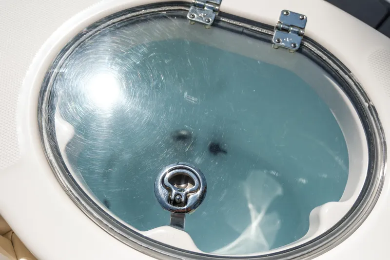 Slide: The Image of 2023 Robalo R302 Center Console boat livewell with a clear lid and latch. - 29
