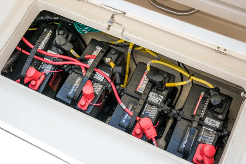Slide: The Image of 2023 Robalo R302 Center Console boat battery compartment with multiple batteries and wiring. - 30
