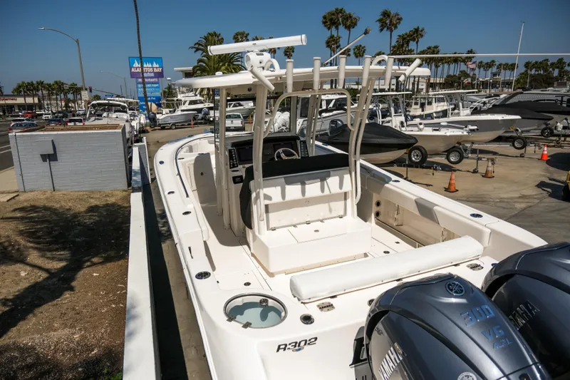 Slide: The Image of 2023 Robalo R302 Center Console boat displayed at a marina with Yamaha engines. - 33