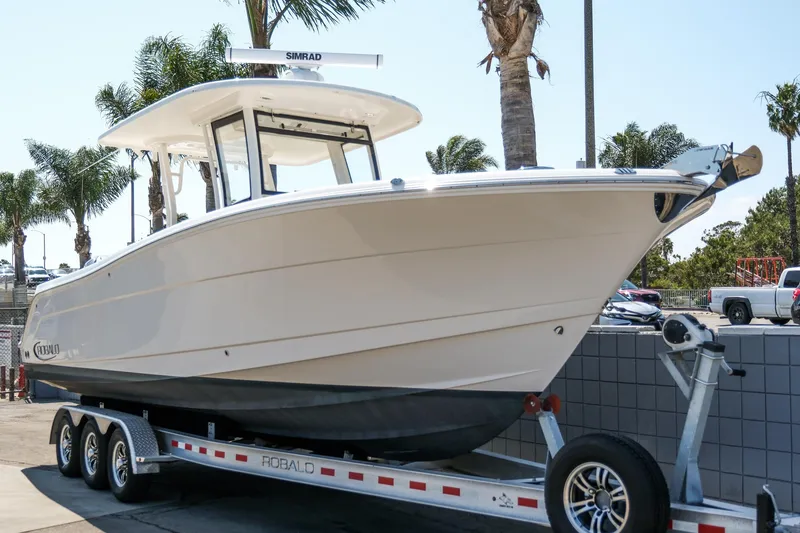 Slide: The Image of 2023 Robalo R302 Center Console boat on trailer, parked outdoors. - 4