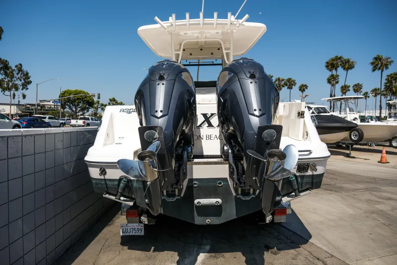 Slide: The Image of 2023 Robalo R302 Center Console boat with dual outboard engines at a marina. - 7