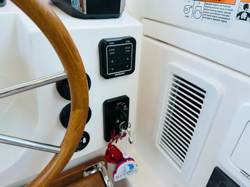 Slide: The Image of Helm controls of a 2021 Back Cove 34O boat with wooden steering wheel and ignition keys. - 11