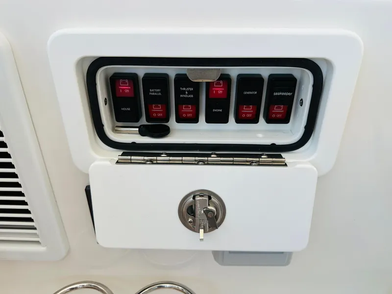 Slide: The Image of Control panel of a 2021 Back Cove 34O boat with labeled switches and lock. - 13