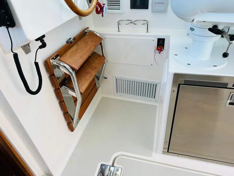 Slide: The Image of Interior of 2021 Back Cove 34O boat with wooden steps and stainless steel appliances. - 15
