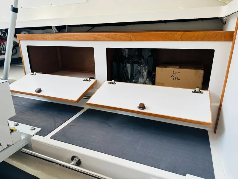 Slide: The Image of 2021 Back Cove 34O storage compartments with open wooden doors and visible interior. - 16