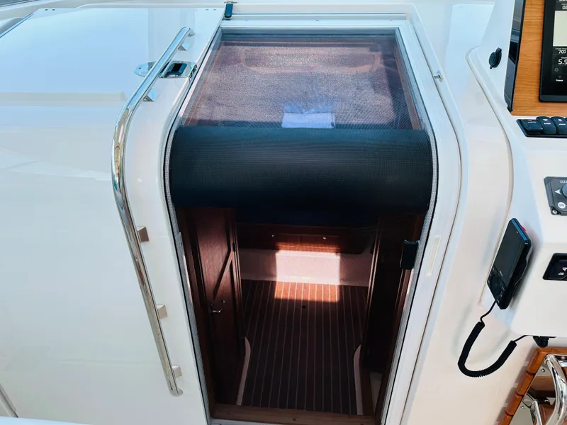 Slide: The Image of 2021 Back Cove 34O cabin entrance with wooden flooring and modern design. - 21