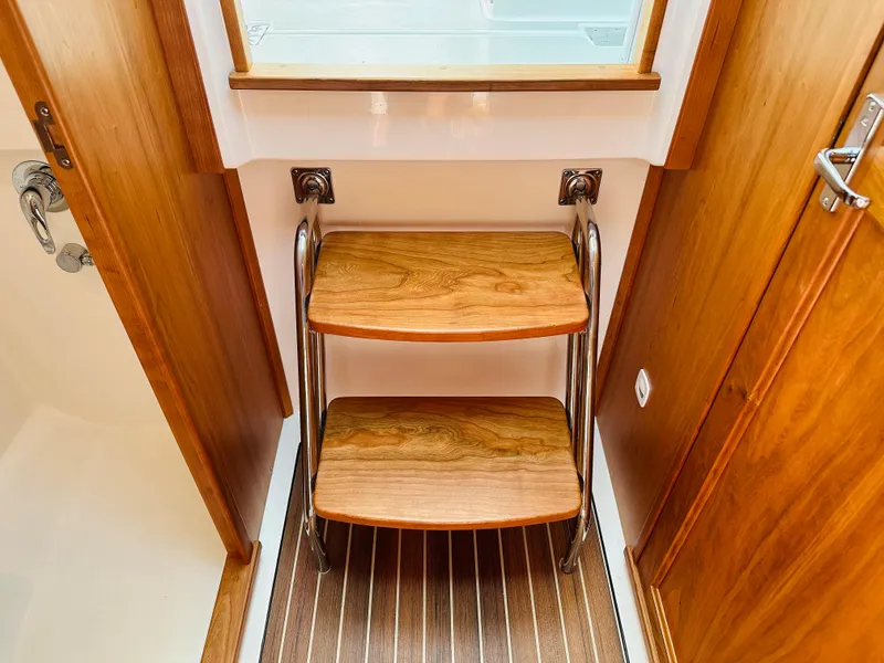 Slide: The Image of Wooden steps inside a 2021 Back Cove 34O boat, featuring elegant wood paneling. - 28