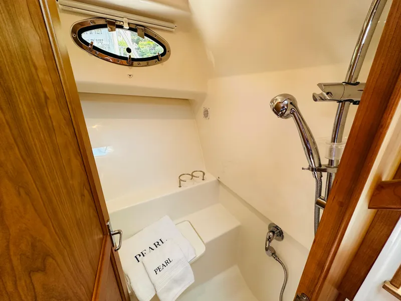 Slide: The Image of 2021 Back Cove 34O yacht bathroom with shower, wooden door, and towel labeled 'PEARL'. - 29