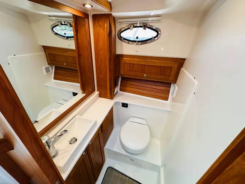 Slide: The Image of 2021 Back Cove 34O yacht bathroom with wooden cabinetry, sink, and toilet. - 30