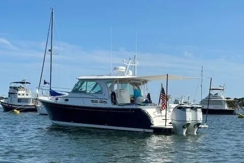 Slide: The Image of 2021 Back Cove 34O boat anchored in a marina with other vessels. - 6