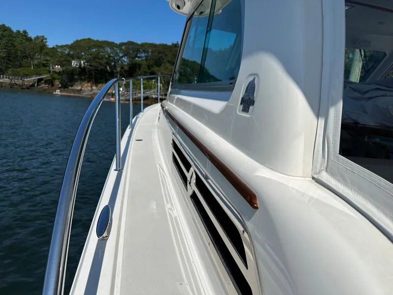 Slide: The Image of 2021 Back Cove 34O yacht side view with sleek design and railing, on calm water. - 7