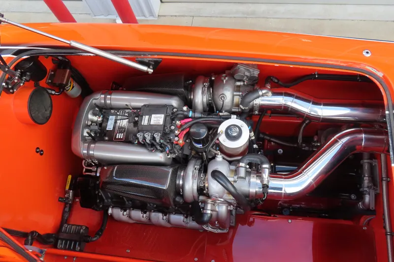 Slide: The Image of High-performance engine of 2005 MTI 44 boat with polished components and vibrant orange detailing. - 19