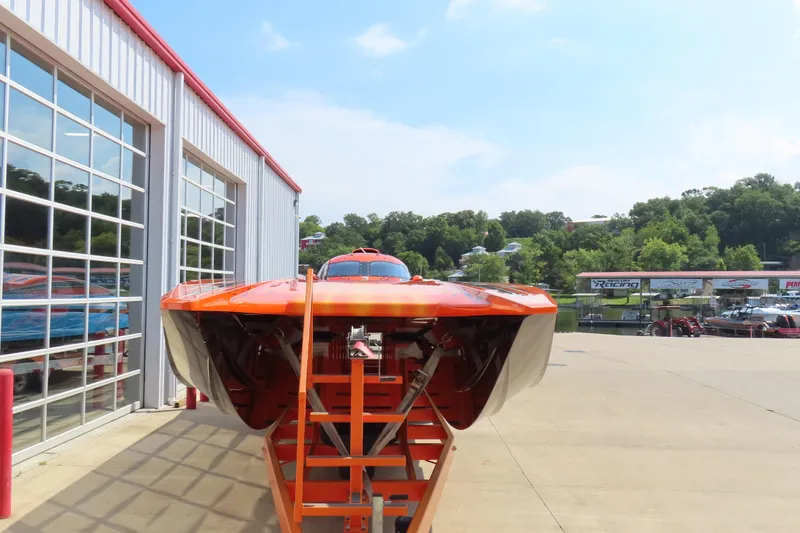 Slide: The Image of Orange MTI 44 powerboat from 2005 on a trailer outside a garage. - 3