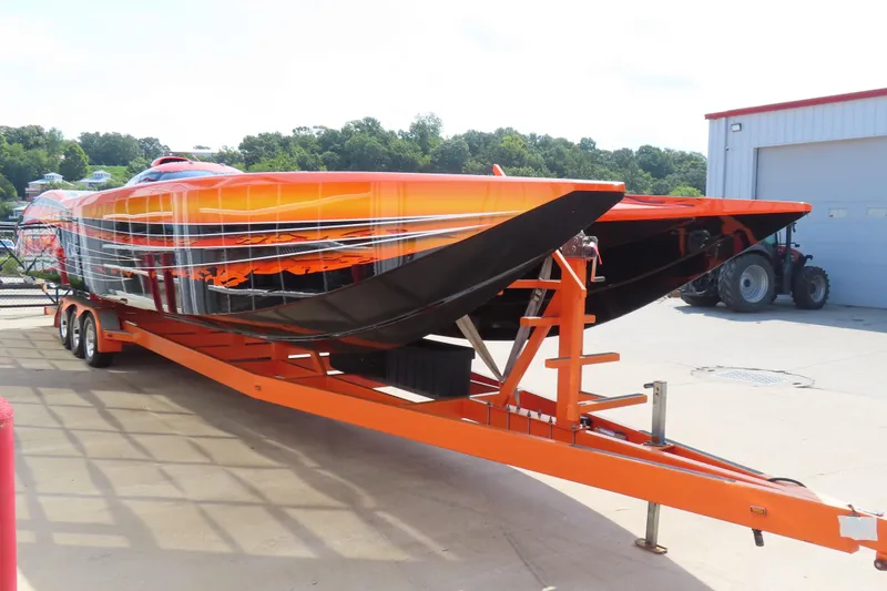 Slide: The Image of Orange MTI 44 speedboat on trailer, 2005 model, parked outdoors near a garage. - 4