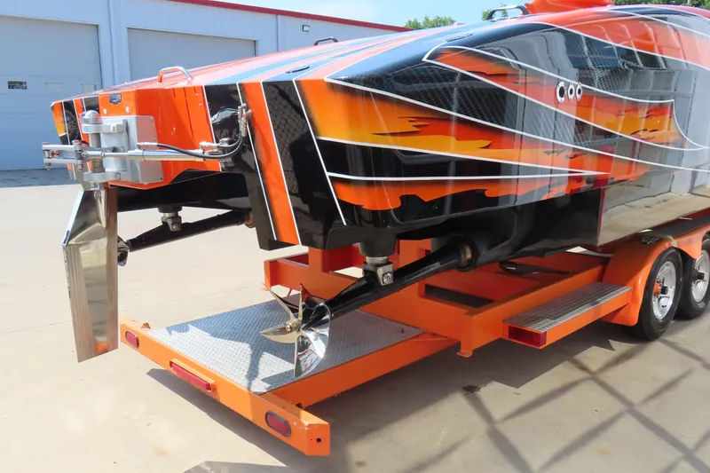 Slide: The Image of Orange and black MTI 44 speedboat on trailer, showcasing sleek design and vibrant graphics. - 6