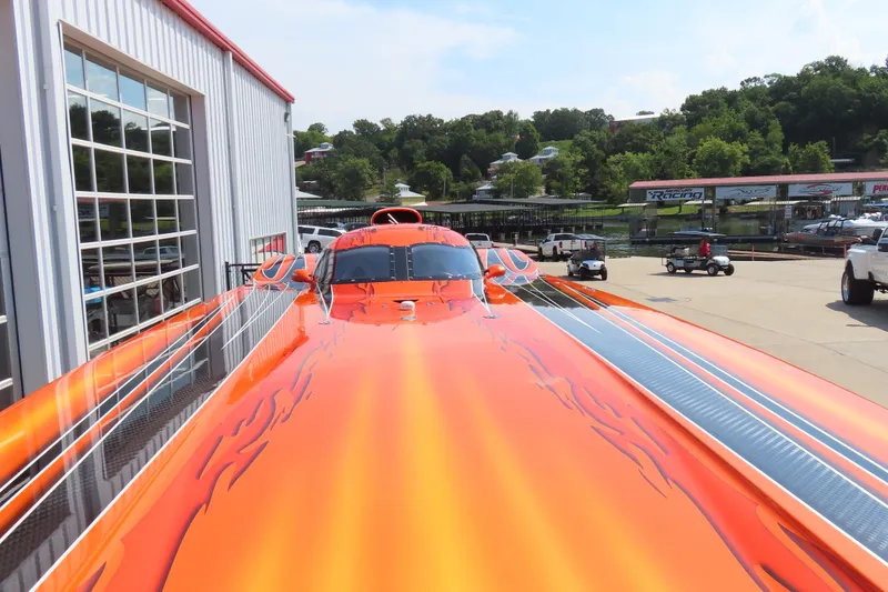Slide: The Image of Orange MTI 44 speedboat with flame design, parked near a marina, 2005 model. - 7