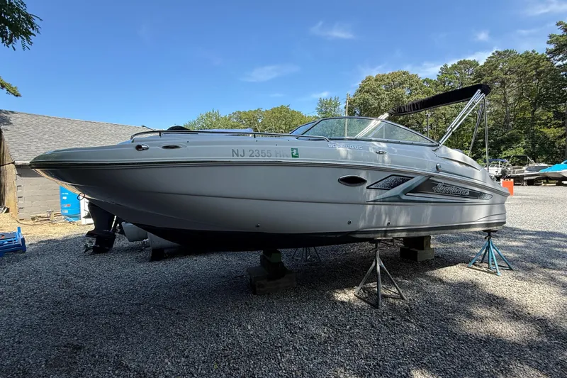 Slide: The Image of 2016 Hurricane SunDeck 2200 DC OB boat on stands, outdoors, under clear blue sky. - 1