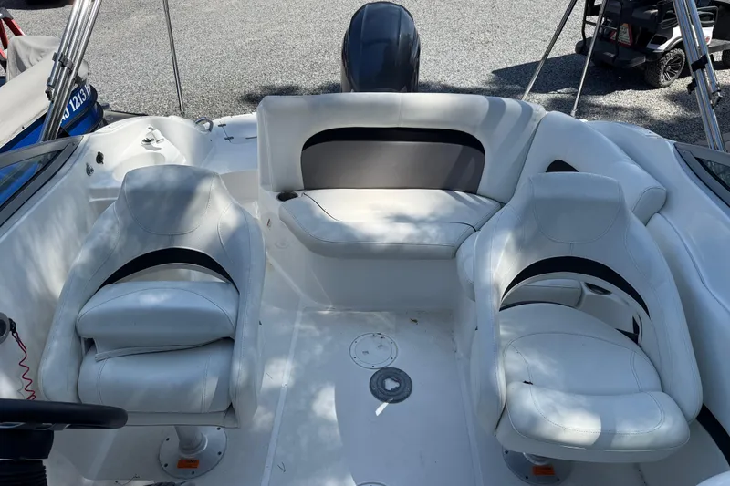 Slide: The Image of 2016 Hurricane SunDeck 2200 DC OB boat interior with white seating and steering wheel. - 10