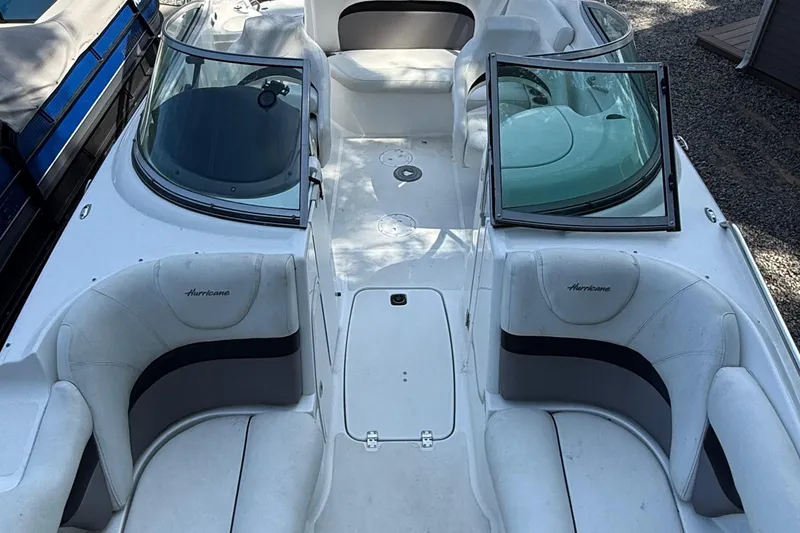 Slide: The Image of 2016 Hurricane SunDeck 2200 DC OB boat interior with white seating and open windshield. - 16