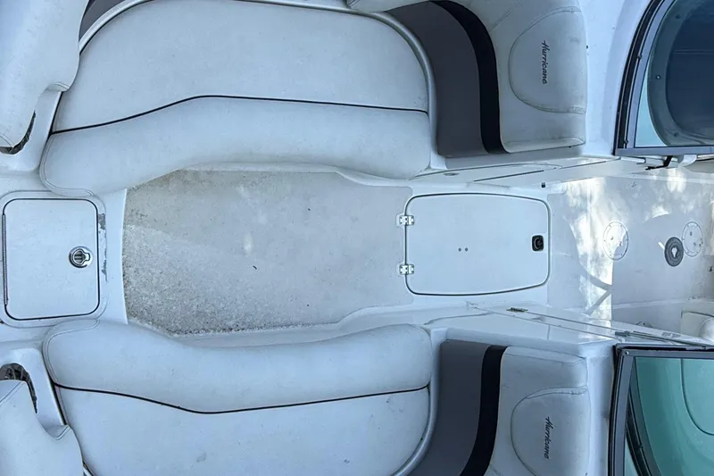 Slide: The Image of 2016 Hurricane SunDeck 2200 DC OB boat interior with white seating and storage compartments. - 18