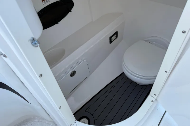 Slide: The Image of 2016 Hurricane SunDeck 2200 DC OB boat interior bathroom with toilet and storage. - 20