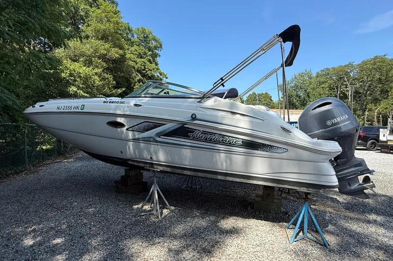 Slide: The Image of 2016 Hurricane SunDeck 2200 DC OB boat on stands, outdoors, with Yamaha outboard motor. - 4