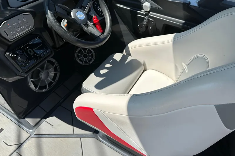 Slide: The Image of 2018 Axis T22 boat interior with steering wheel, control panel, and white-red seat. - 13
