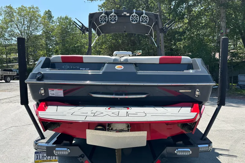 Slide: The Image of 2018 Axis T22 boat rear view with speakers and swim platform, parked outdoors. - 3