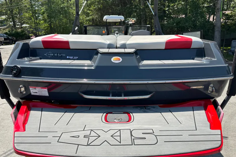 Slide: The Image of 2018 Axis T22 boat rear view with red and gray accents, parked outdoors. - 4