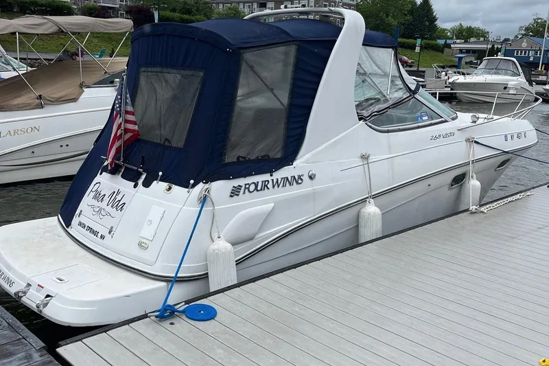 Slide: The Image of 2002 Four Winns 268 Vista boat docked at marina with American flag. - 2